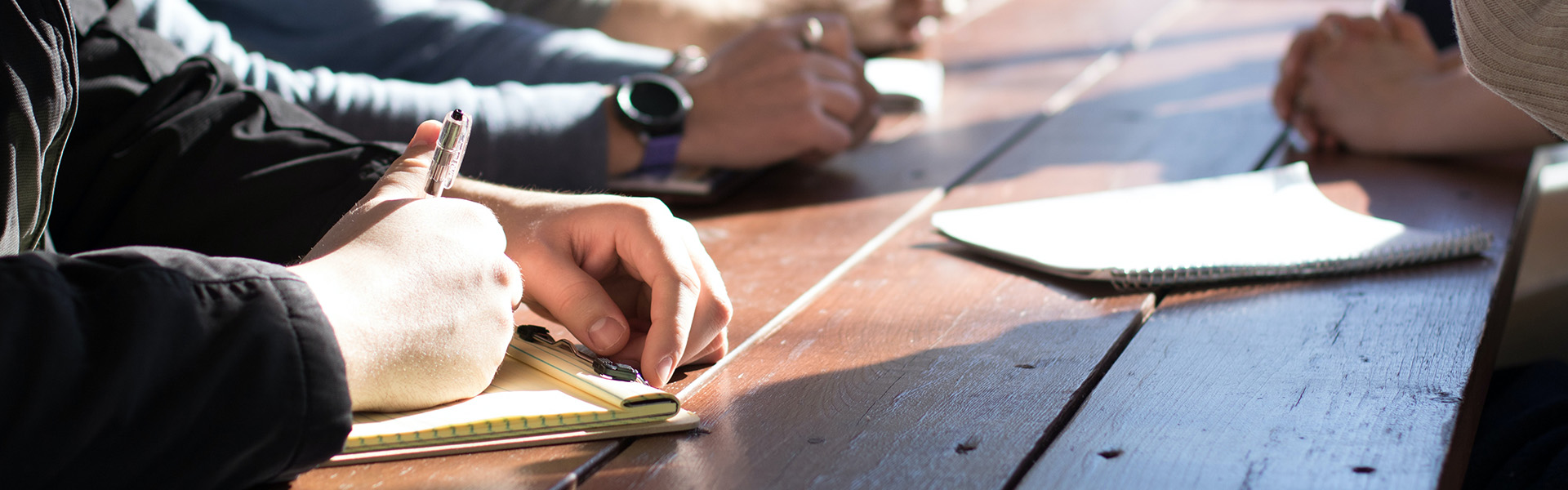 Drei Personen machen sich Notizen während einer Besprechung | Kontaktieren Sie uns und lassen Sie sich von unseren Experten bei GERDITEX unverbindlich beraten!